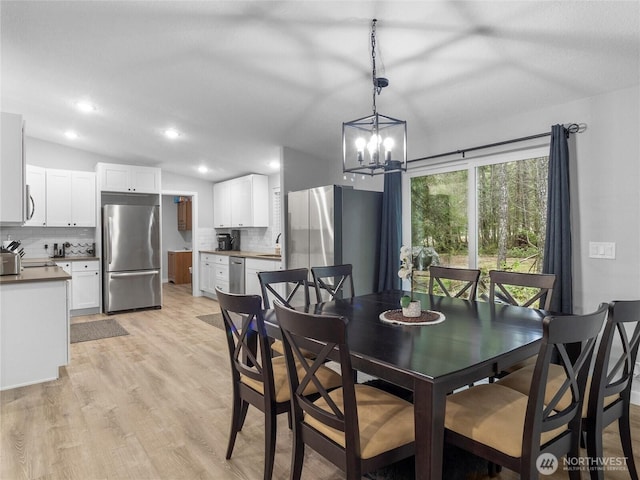 dining room featuring recessed lighting, vaulted ceiling, and light wood finished floors