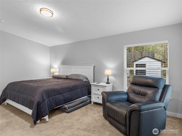 bedroom with light carpet, baseboards, and a textured ceiling