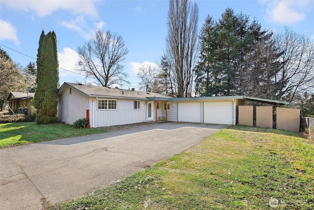 view of front of house featuring an attached garage, aphalt driveway, and a front yard