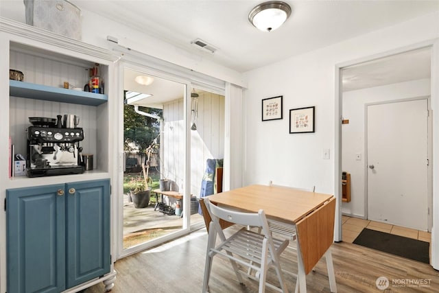 dining room featuring light wood-style flooring and visible vents