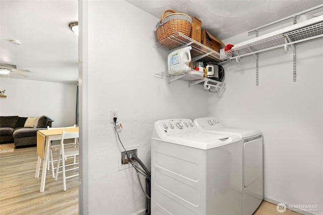 clothes washing area featuring washer and dryer, laundry area, ceiling fan, and light wood finished floors