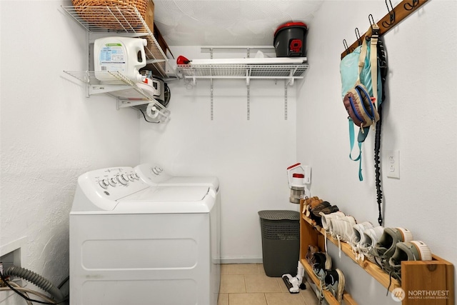 washroom with laundry area, washer and dryer, and light tile patterned flooring