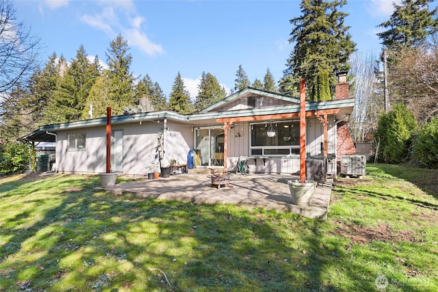 back of property featuring a patio area, central AC, a chimney, and a lawn