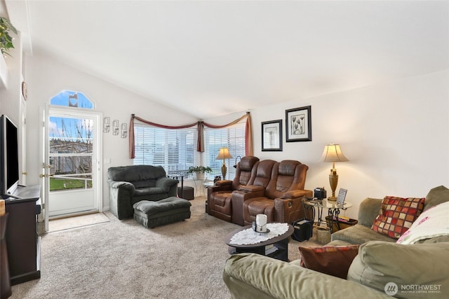 living room featuring plenty of natural light, lofted ceiling, and carpet flooring