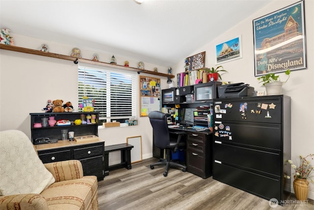 office area with baseboards, wood finished floors, and vaulted ceiling