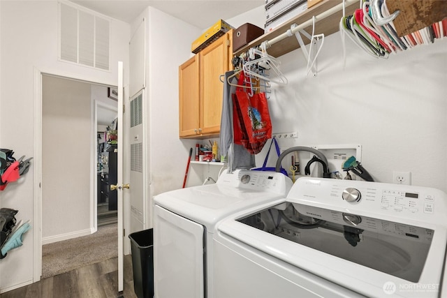 clothes washing area with visible vents, baseboards, dark wood-style floors, cabinet space, and separate washer and dryer