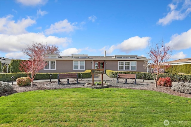 rear view of property featuring a lawn