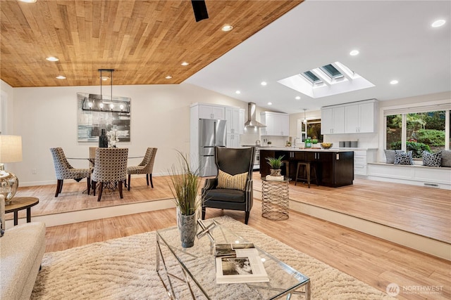 living room with vaulted ceiling with skylight, visible vents, wooden ceiling, light wood-type flooring, and recessed lighting