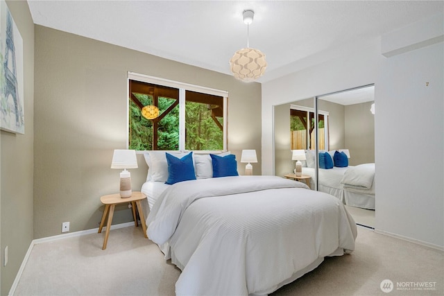 bedroom featuring light carpet, baseboards, and a closet