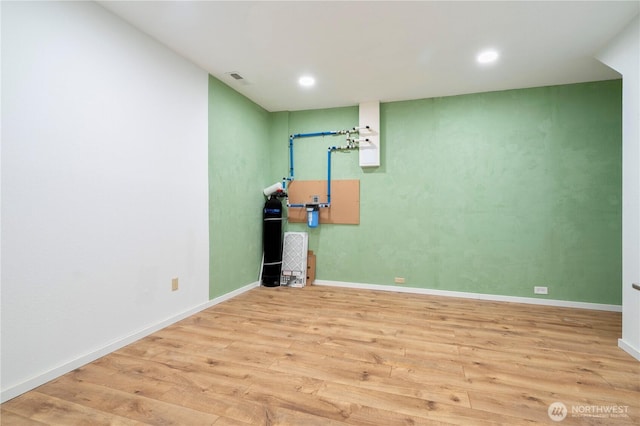 below grade area featuring recessed lighting, wood finished floors, visible vents, and baseboards