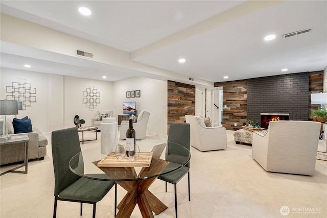 dining room featuring a brick fireplace, visible vents, and recessed lighting