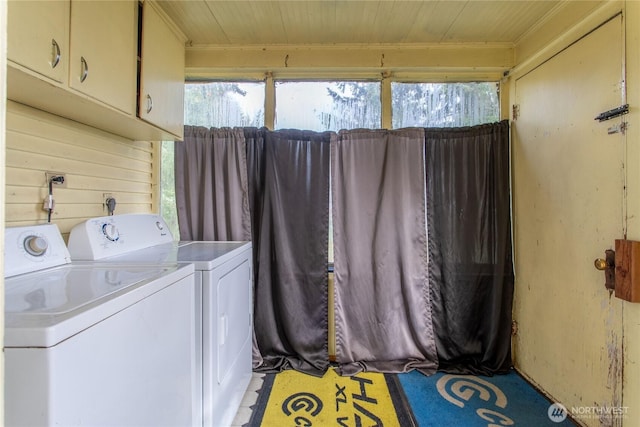 washroom featuring washer and dryer, wood ceiling, and cabinet space