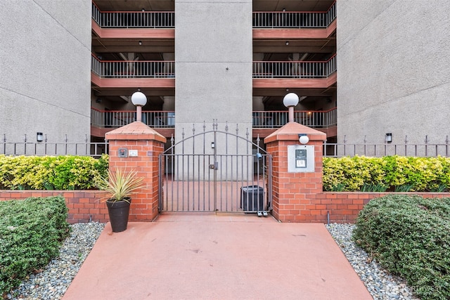 view of gate featuring fence and central AC unit