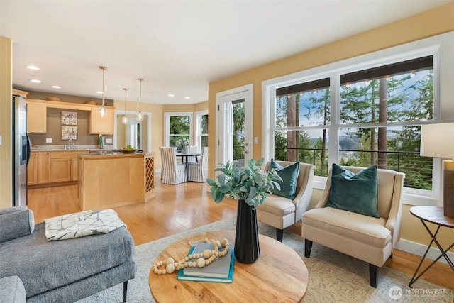 living room with recessed lighting, light wood-style flooring, and baseboards