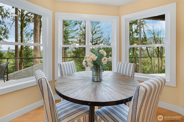 dining area featuring baseboards and light wood-type flooring