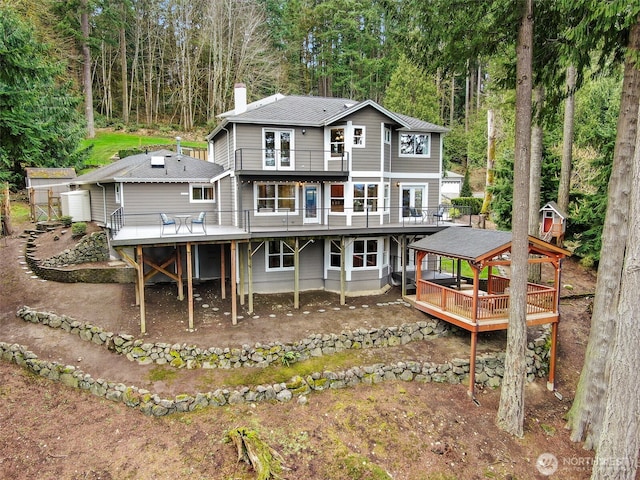 back of property featuring a chimney and a wooden deck