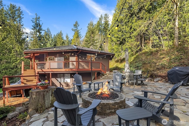 back of house with outdoor dining space, stairway, a fire pit, a wooden deck, and a patio area