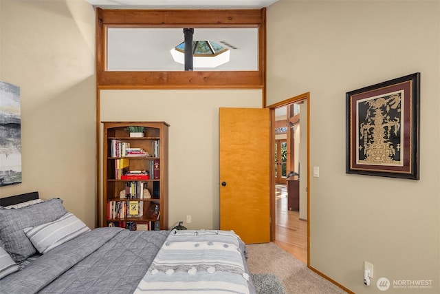 bedroom featuring a high ceiling and carpet flooring