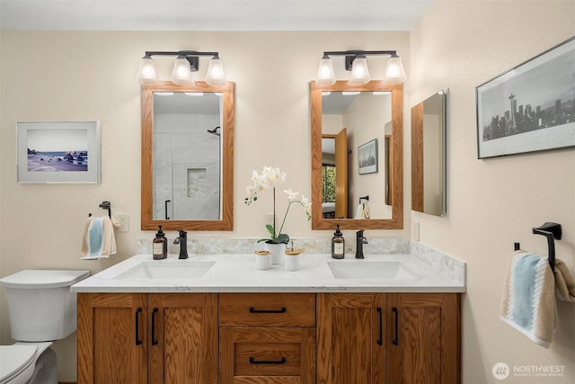 bathroom featuring double vanity, toilet, a shower, and a sink