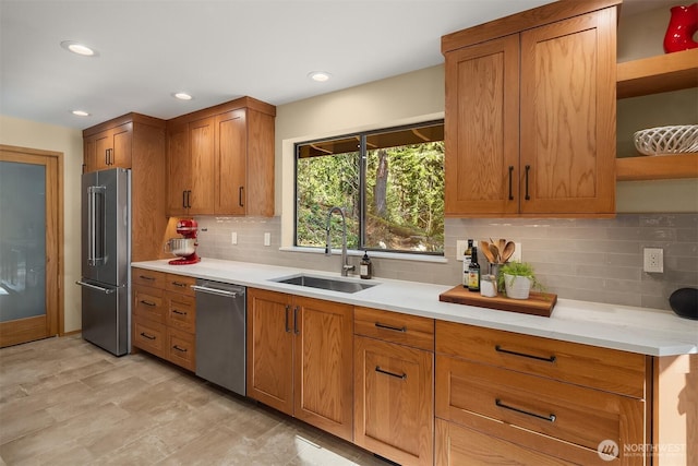 kitchen with tasteful backsplash, a sink, brown cabinets, stainless steel appliances, and open shelves