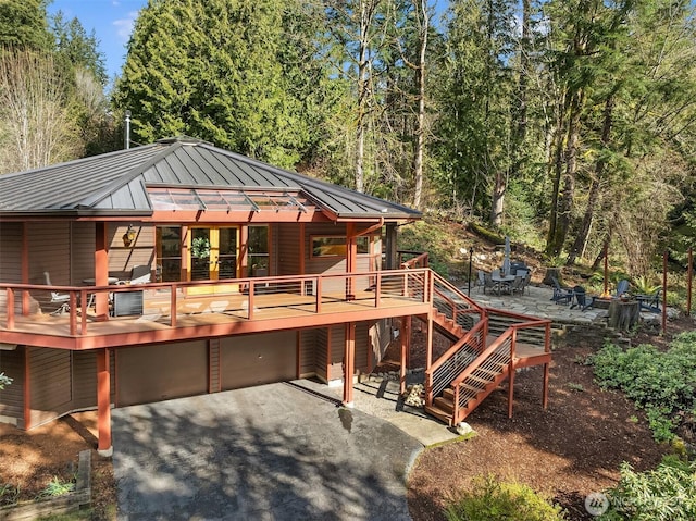 rear view of house with metal roof, a patio area, stairs, and a standing seam roof