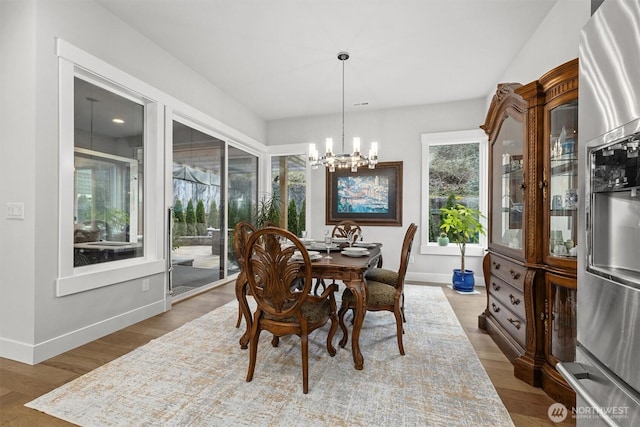 dining area with a notable chandelier, baseboards, and wood finished floors