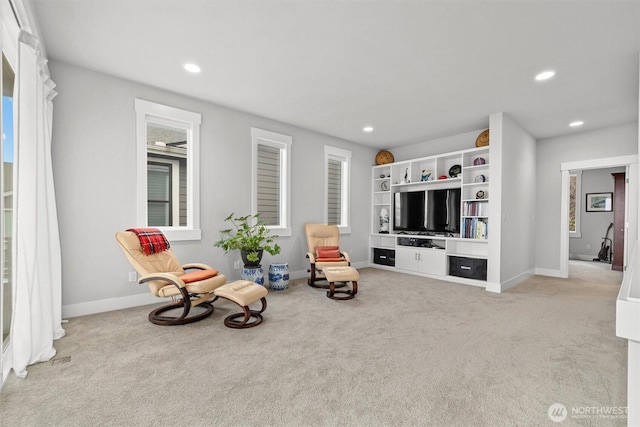 living area featuring recessed lighting, baseboards, and light colored carpet