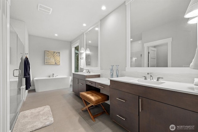 full bathroom featuring a stall shower, a sink, and tile patterned floors