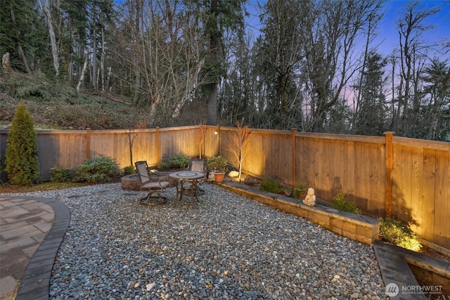 yard at dusk with a fenced backyard and a patio