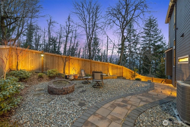 view of patio / terrace featuring an outdoor fire pit, cooling unit, and a fenced backyard