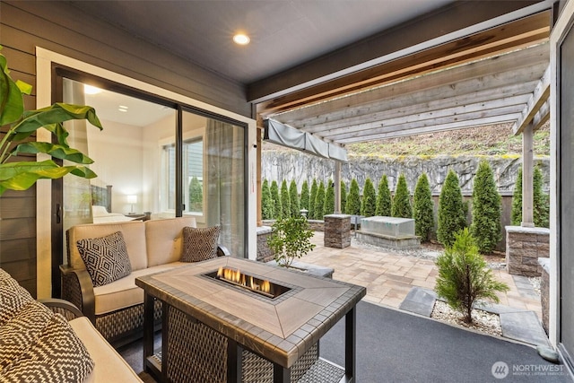 view of patio with an outdoor living space with a fire pit