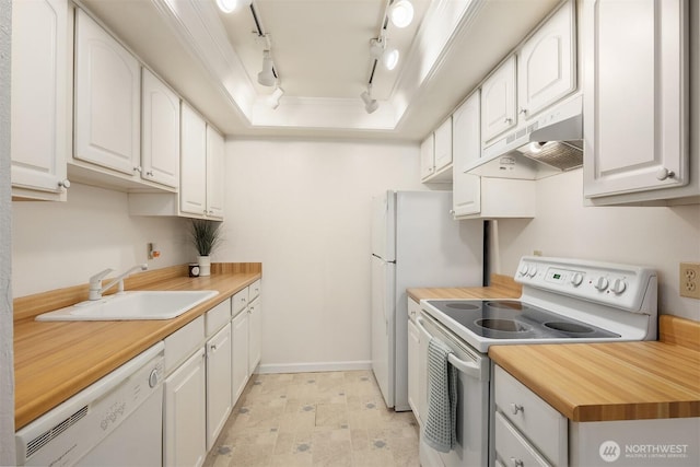 kitchen with a raised ceiling, white cabinets, a sink, white appliances, and under cabinet range hood