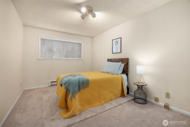 bedroom featuring a textured ceiling, carpet floors, baseboard heating, and baseboards