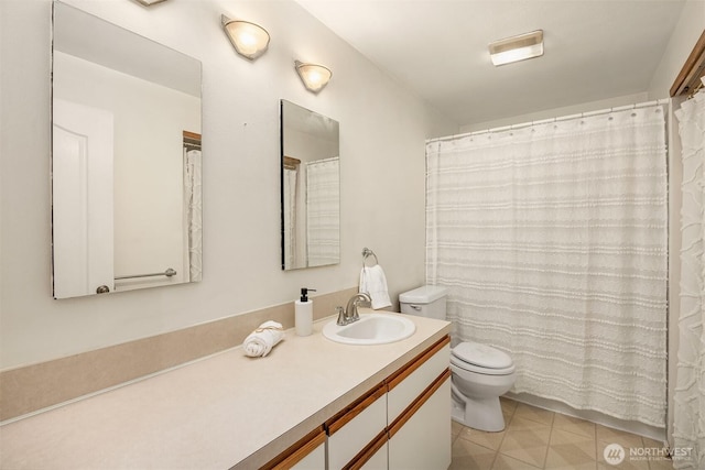 bathroom with tile patterned flooring, vanity, and toilet