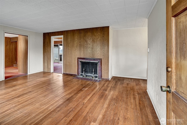 unfurnished living room with a brick fireplace and wood finished floors