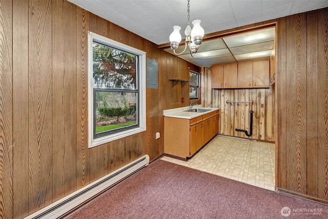 kitchen featuring light countertops, wooden walls, and baseboard heating