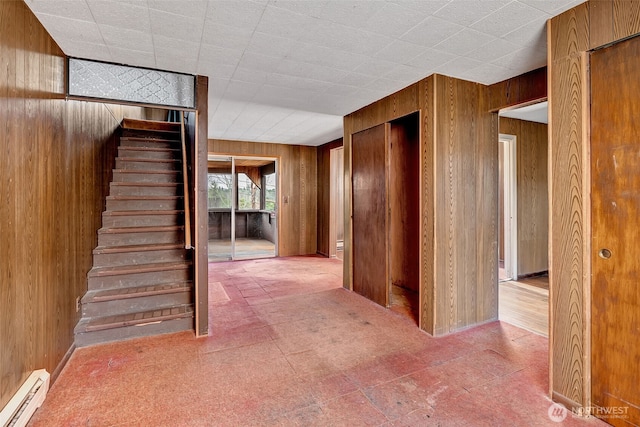 interior space with baseboard heating and wood walls