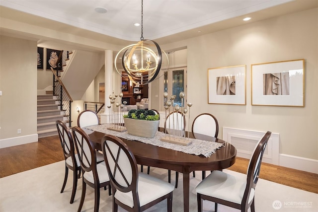 dining room featuring baseboards, a chandelier, stairway, recessed lighting, and wood finished floors