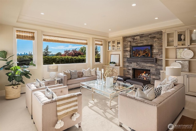 living area featuring recessed lighting, a tray ceiling, ornamental molding, and a fireplace