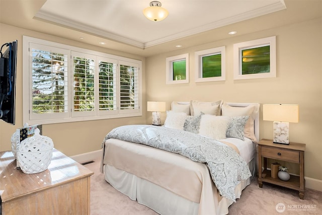 carpeted bedroom with a raised ceiling, multiple windows, visible vents, and ornamental molding