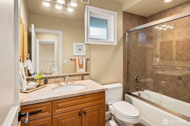 full bath with visible vents, toilet, vanity, and bath / shower combo with glass door