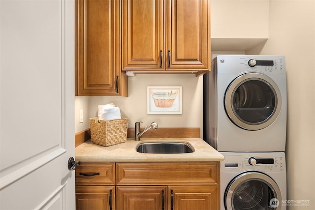 laundry room with a sink, stacked washer / drying machine, and cabinet space