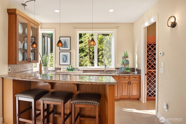 bar with light tile patterned floors, recessed lighting, a sink, decorative light fixtures, and backsplash