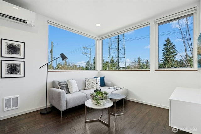 interior space with an AC wall unit, dark wood-type flooring, visible vents, and baseboards