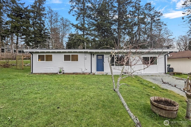 ranch-style home with gravel driveway and a front yard