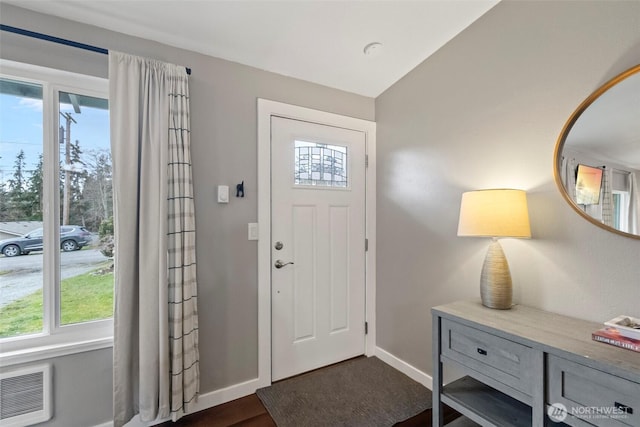 foyer with baseboards and dark wood-style flooring