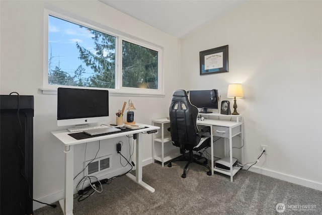 carpeted office space with lofted ceiling and baseboards