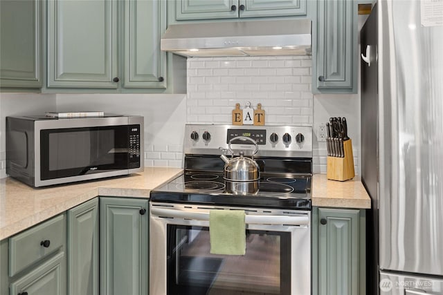 kitchen with stainless steel appliances, light countertops, under cabinet range hood, and green cabinets