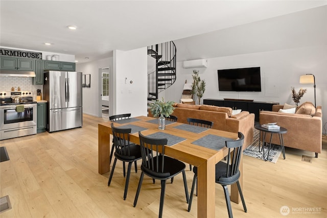 dining room with stairway, recessed lighting, a wall mounted AC, and light wood-style floors