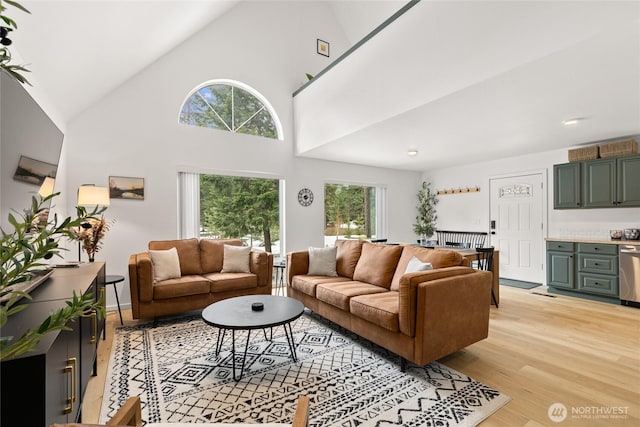 living room with high vaulted ceiling and light wood finished floors